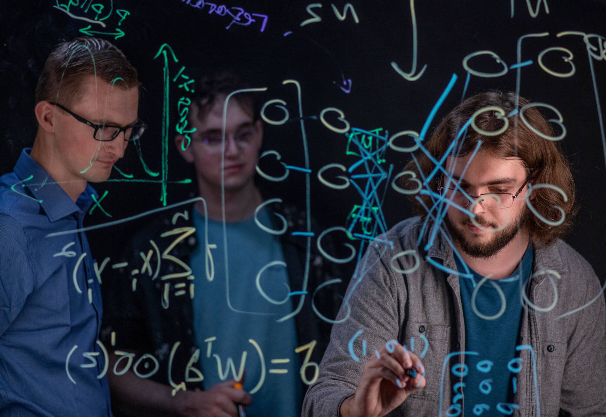 Computing students working on a digital board.